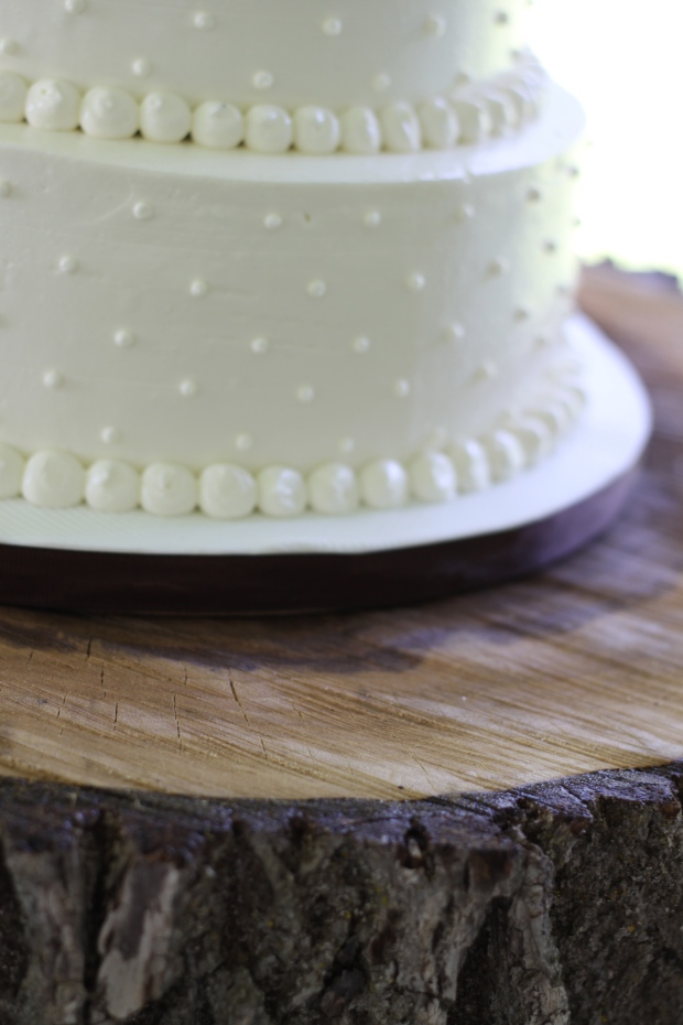 white swiss dot wedding cake on rustic wood cake stand | Tuxedo & Russell's Hudson Valley June Wedding | Brooklyn Homemaker